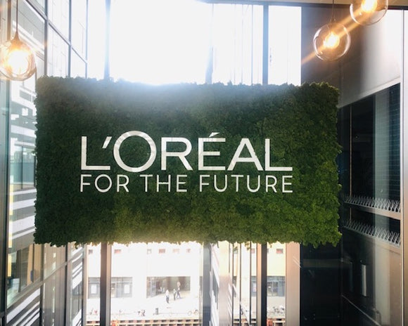 Store grønne velkomstskilte i mos til Loreal i København, Oslo, Helsinki og Stockholm.